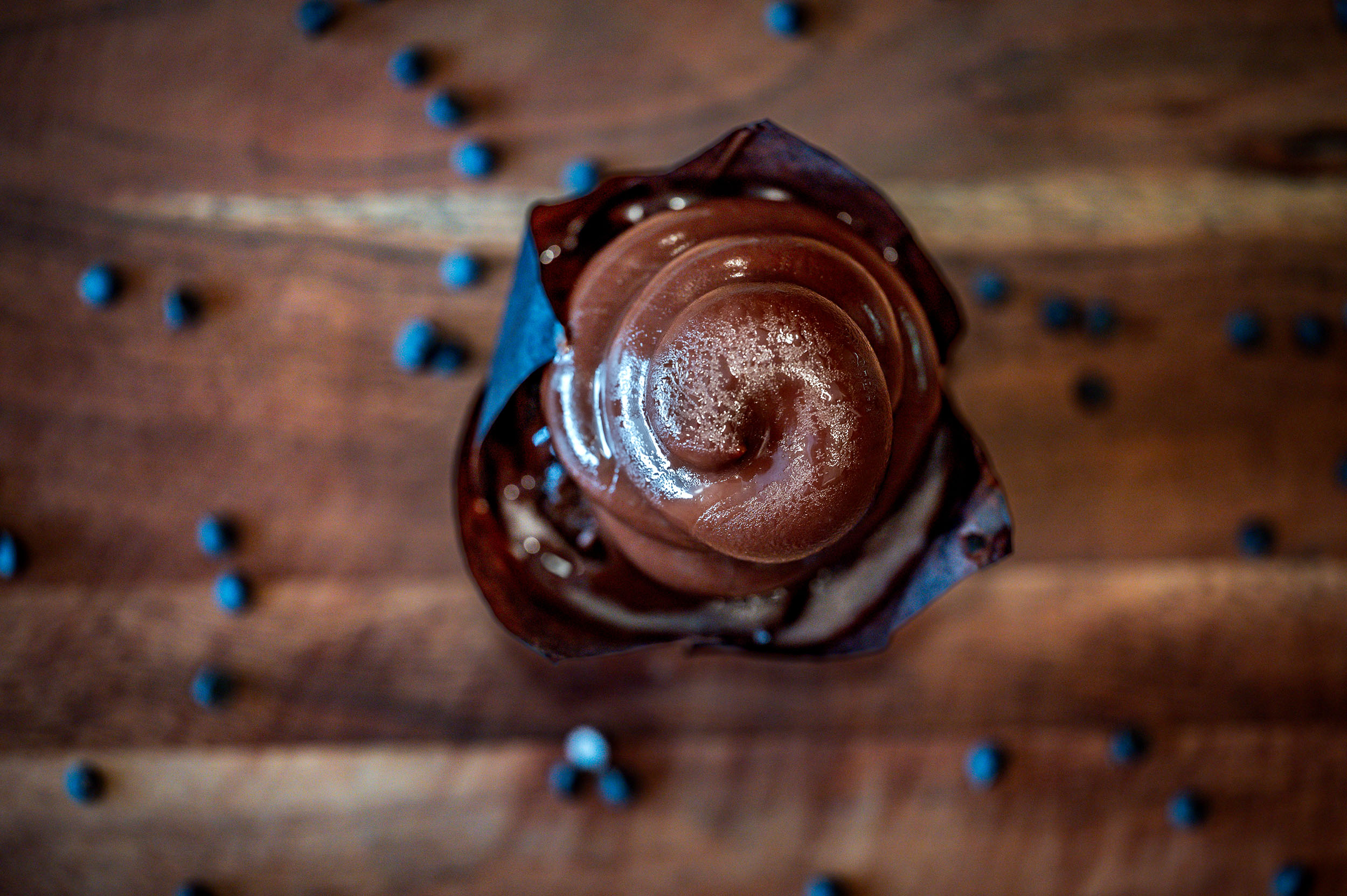 Top view of Hoho cupcake surrounded by chocolate chips. With wood counter top background.